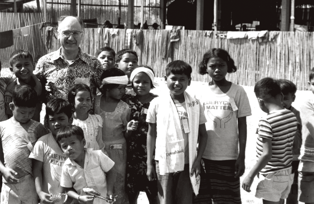 Volunteers at a refugee camp. Children with President Pittau (1980)